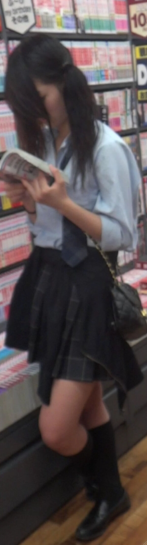 Low-angle image of JK standing reading at a bookstore 11th image