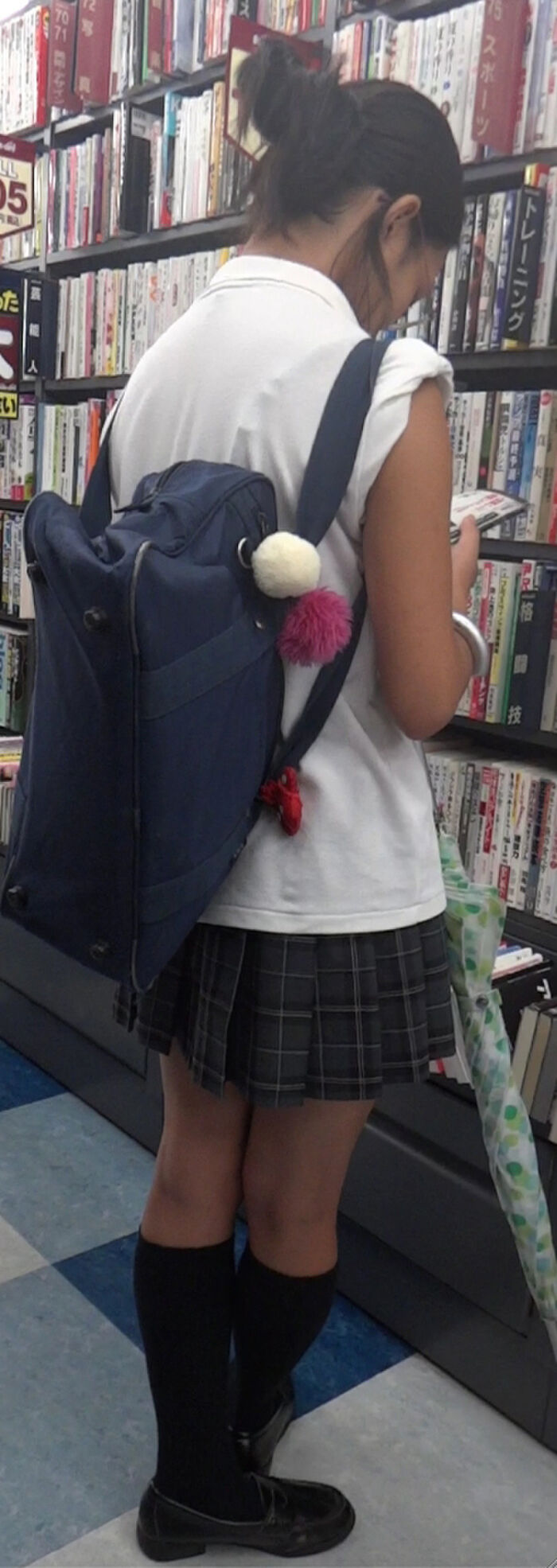 Low-angle image of JK standing reading at a bookstore 17th image