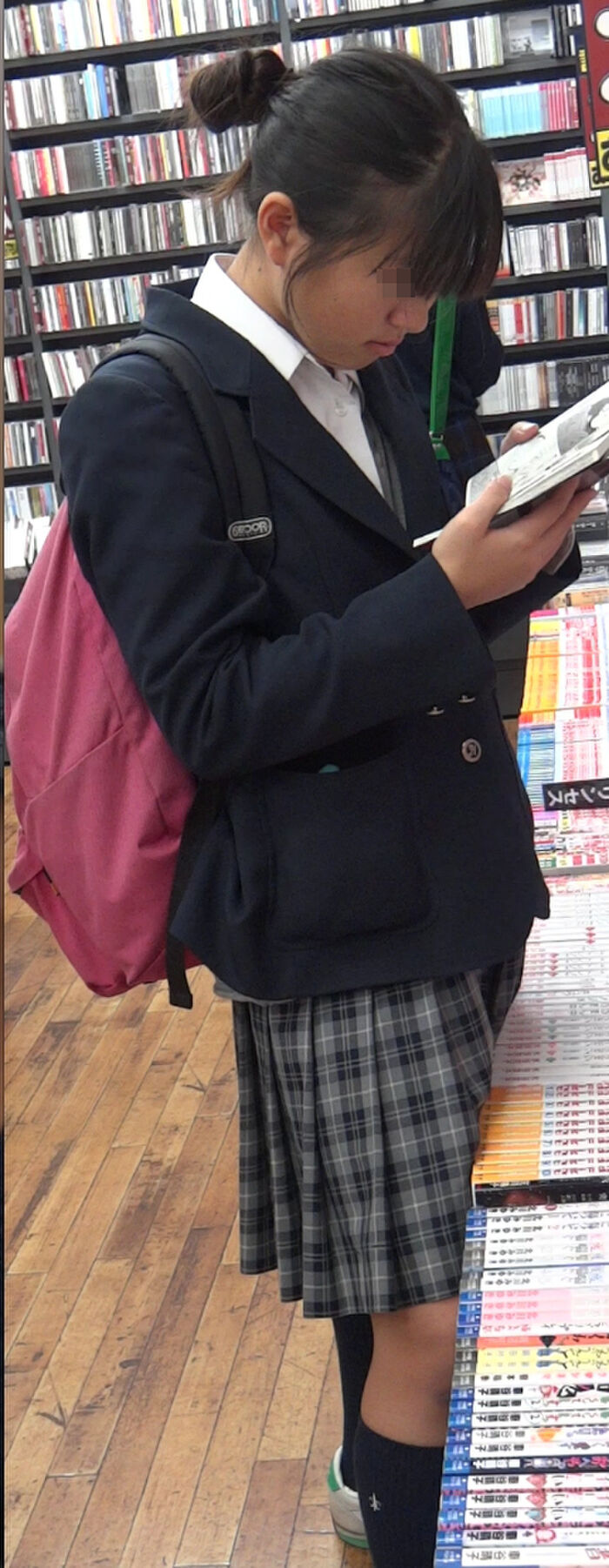 Low-angle image of JK standing reading at a bookstore 2th image