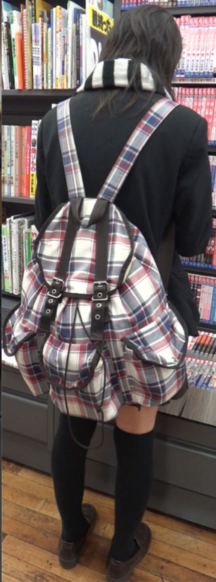 Low-angle image of JK standing reading at a bookstore 5th image