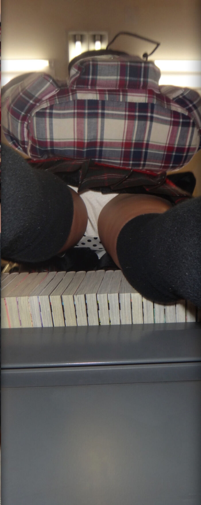 Low-angle image of JK standing reading at a bookstore 7th image
