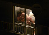 Erotic image looking into the room of a foreigner with the curtains of the window open