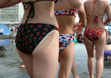 Erotic image of a beach overflowing with the buttocks of a swimsuit gal in the summer sea