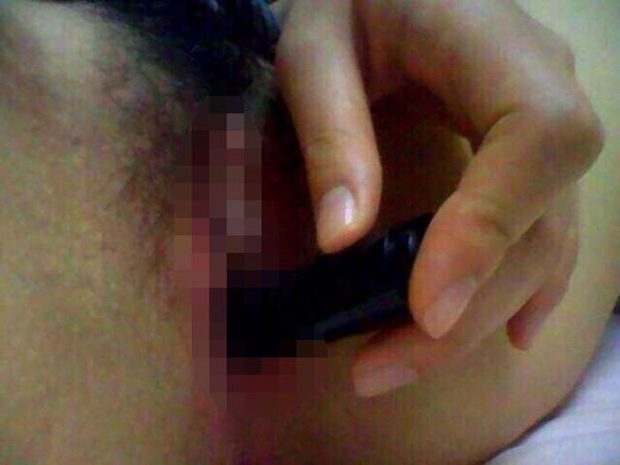 Erotic image of an amateur girl inserting a foreign object in a selfie 14th image