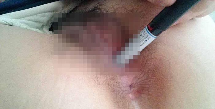 Erotic image of an amateur girl inserting a foreign object in a selfie 15th image