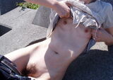 Outdoor exposure erotic image of a thin woman exposing her body outdoors