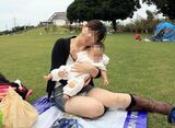 A Mr./Ms. mom with a child squats down and her pants are fully visible erotic image